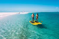 Photo of of a couple paddle boarding on Safari in Mozambique Africa